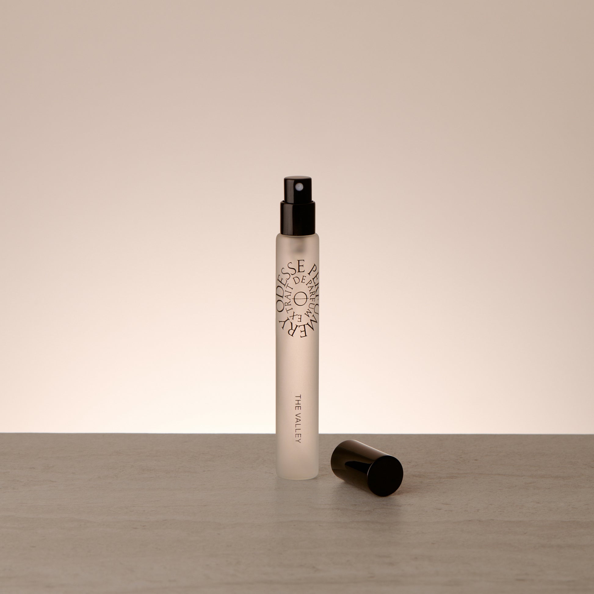 Odesse The Valley Extrait de Parfum 10ml travel-size fragrance styled in a minimal, editorial composition highlighting refined portability
