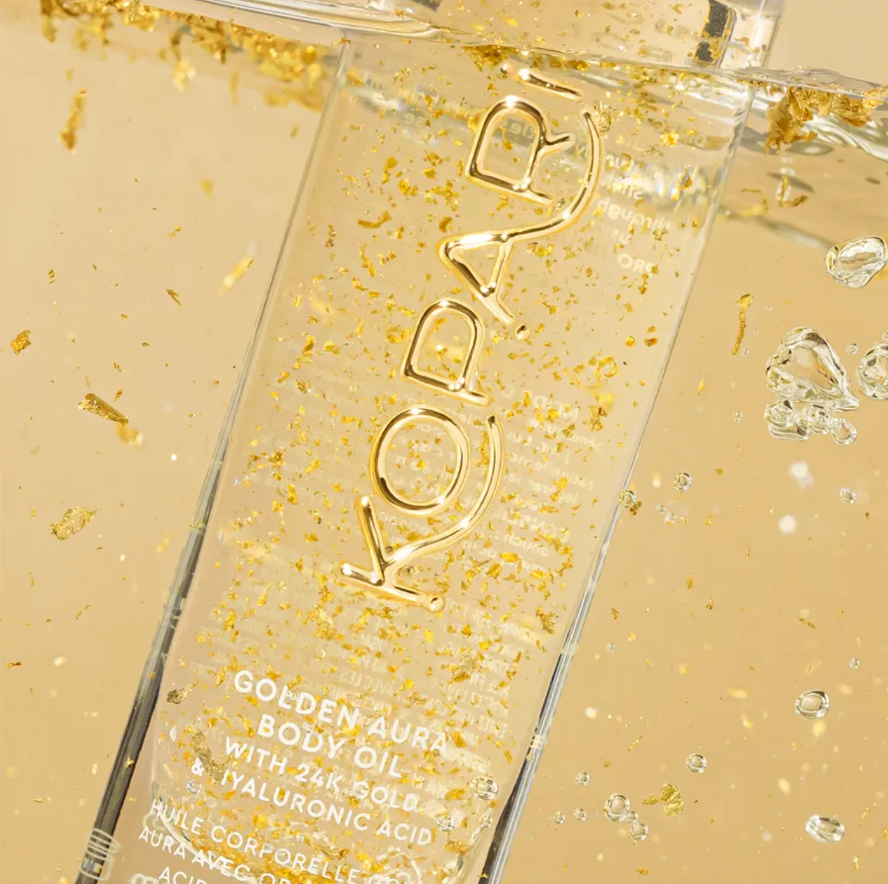 Kopari Golden Aura Body Oil packaging with gold flakes and visible brand name.