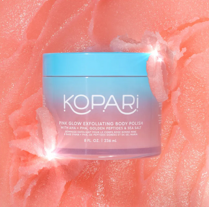 Kopari Pink Glow Exfoliating Body Polish jar on a pink textured background