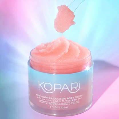 Kopari pink glow exfoliating body polish with a pink scrub on top against a gradient background