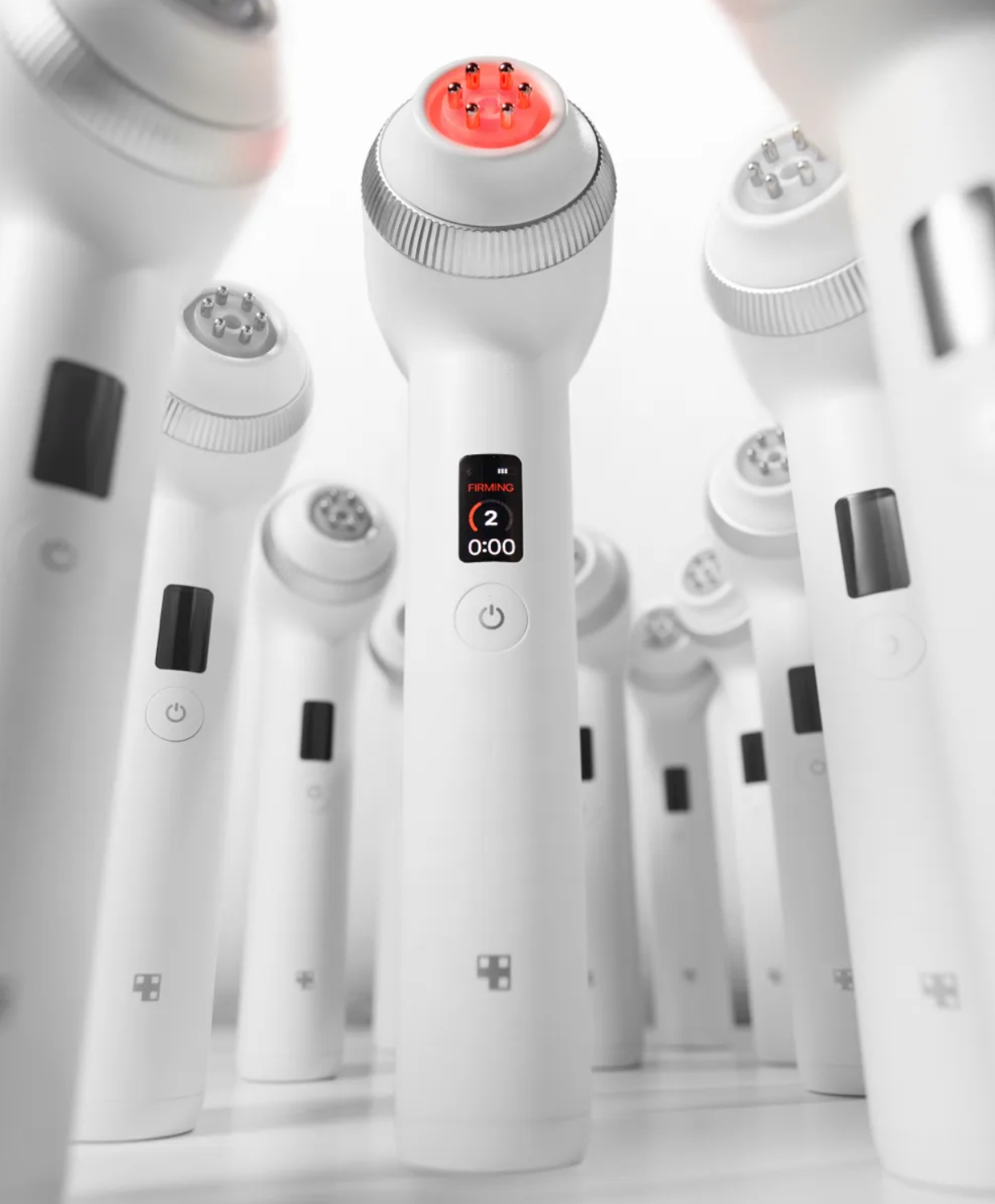 Multiple Medicube Age-R Ultra Tune 40.68 standing up with red lights on a white grey background. 